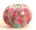 handmade glass lampwork bead, 
					pink flowers over green latticcino, encased